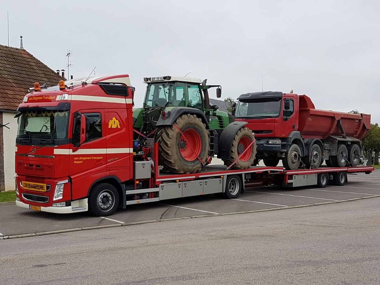 drie mannen zitten in de laadbak van een vrachtwagen